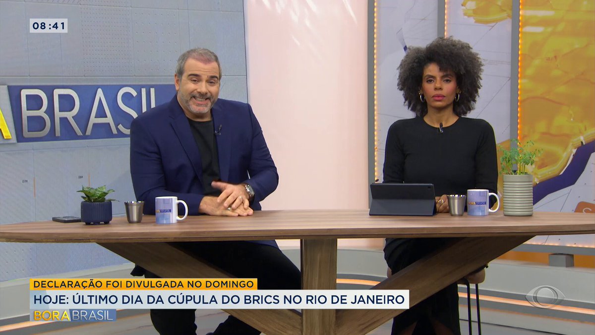 Em resumo, Rodrigo Alvarez e Cynthia Martins na bancada do Bora Brasil (Créditos: Band/Reprodução)